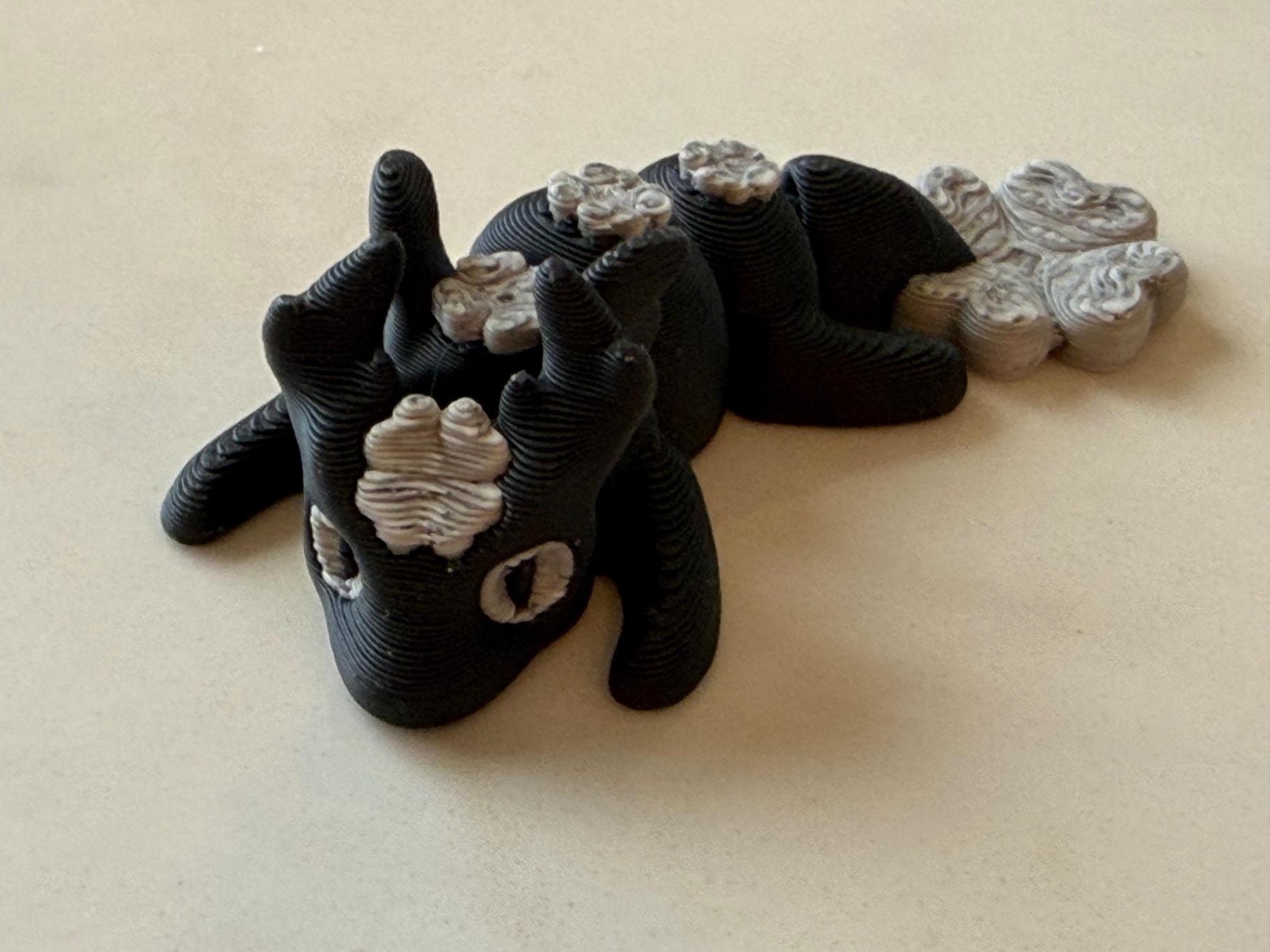 Panda Dragon — Black and cream dragon with paw-print scales