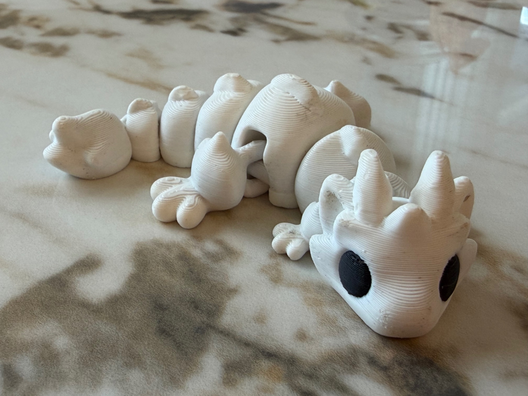 Snow Dragon — Bright white flexi dragon with big dark eyes